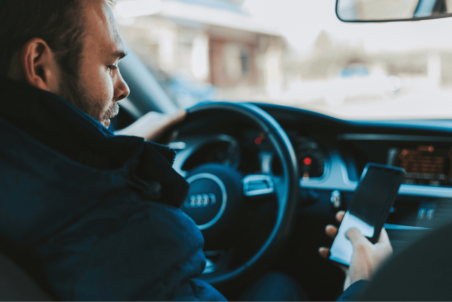 Man driving unsafely with phone in his hand